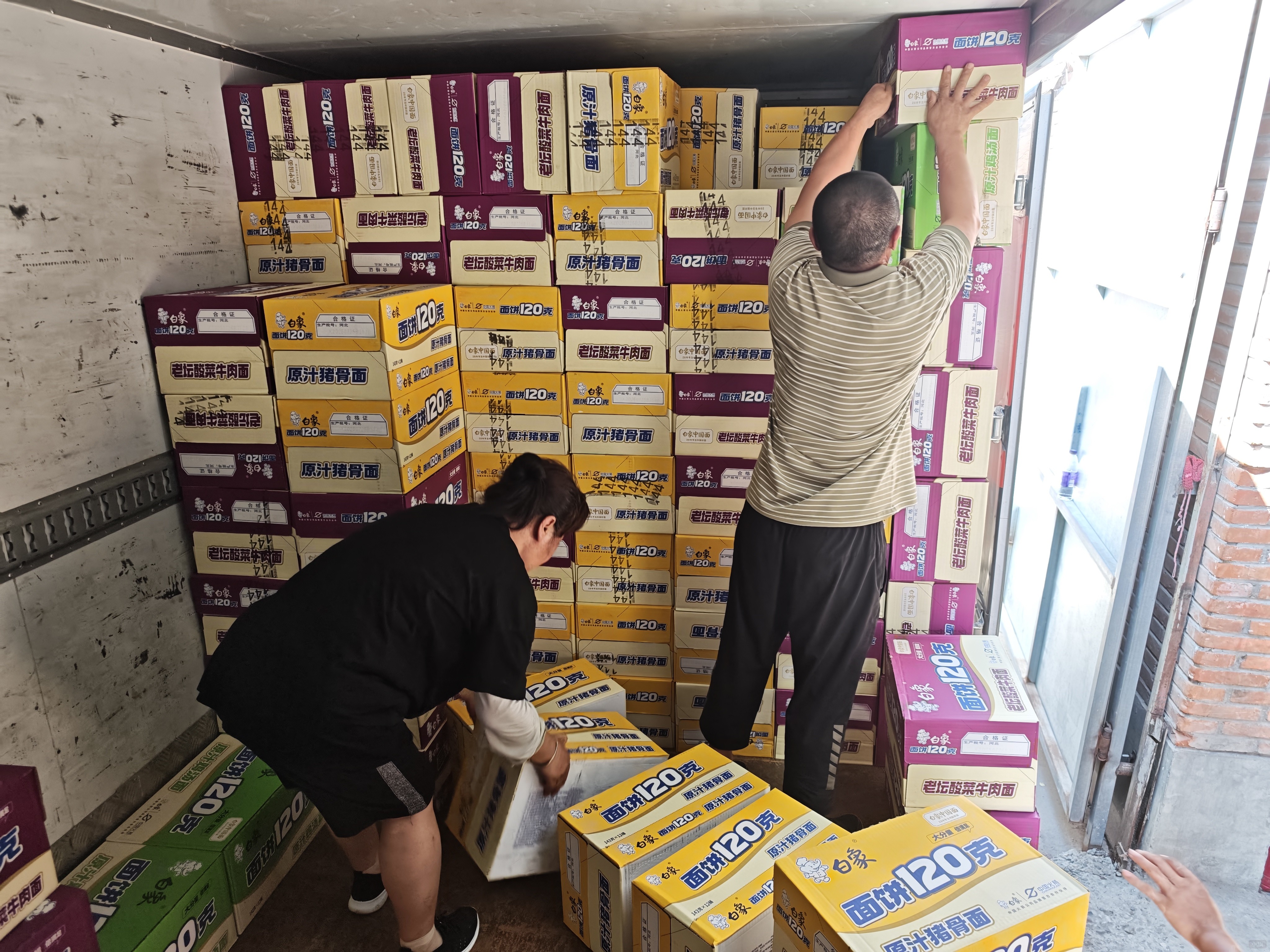 京AA89545的车主在闷热的车厢内摆放运送物资
