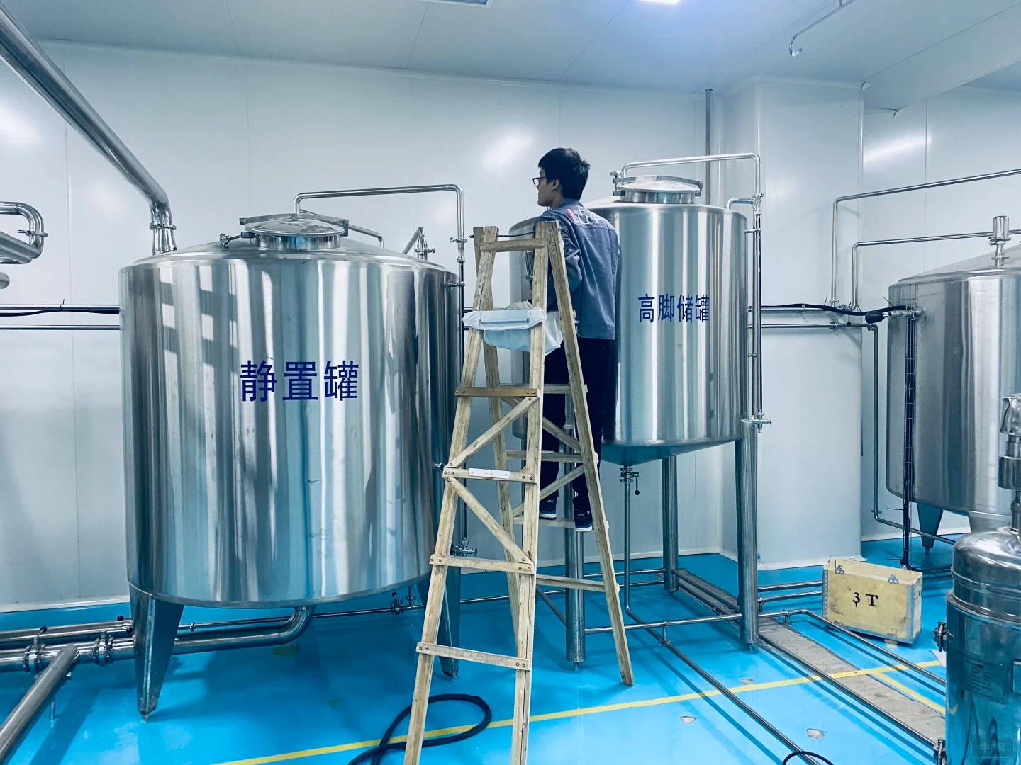 工作人员正在检查饮料厂静置罐 工作人员正在检查饮料厂静置罐